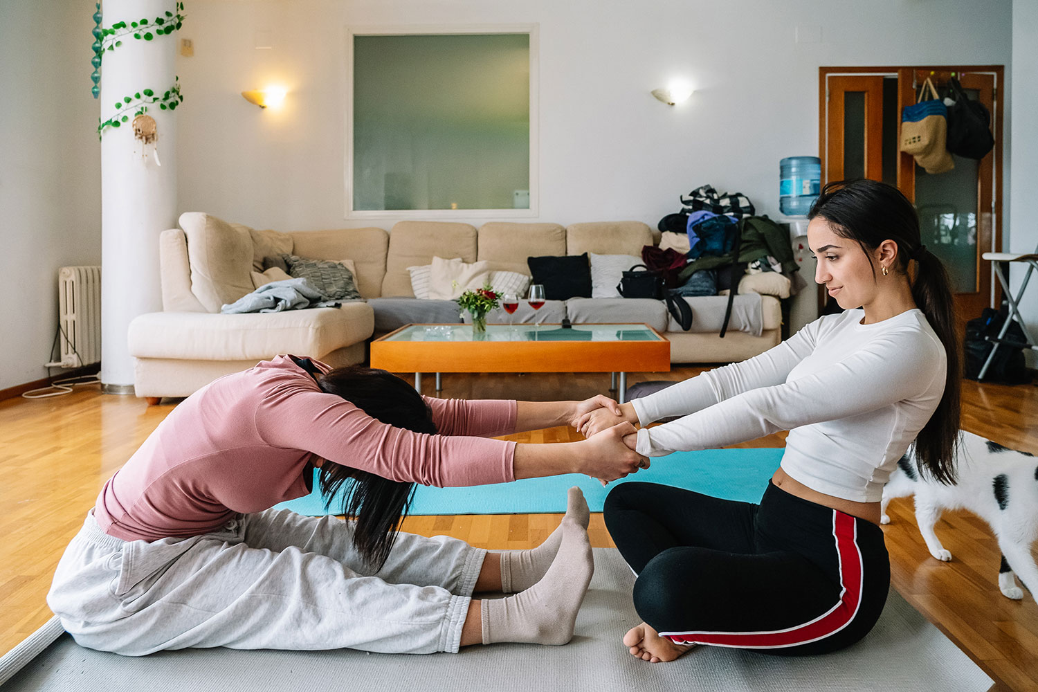 Couple engaging in partner stretching exercise in a cozy indoor setting, promoting health and wellness through physical activity and self-care practices.