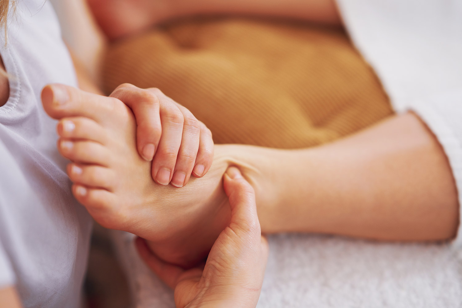 Reflexology session focusing on foot pressure points, demonstrating therapeutic massage technique for overall wellness.